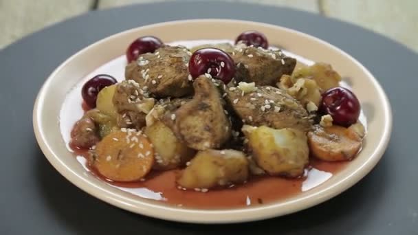 Een Joods gebraden gerecht met kip in kersensaus op een zwarte standaard draait in een cirkel — Stockvideo