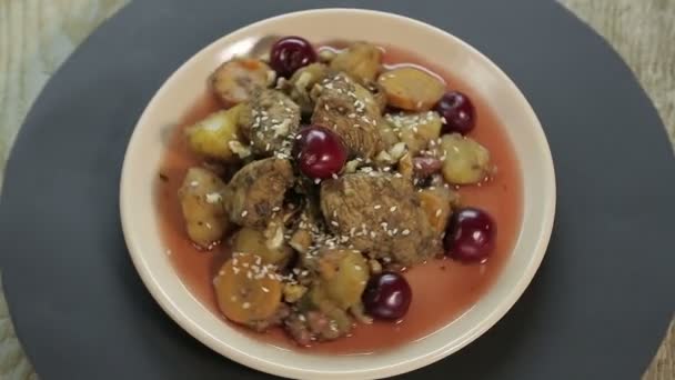 Еврейское жареное блюдо с курицей в вишневом соусе на черном фоне вращается в круге сверху — стоковое видео