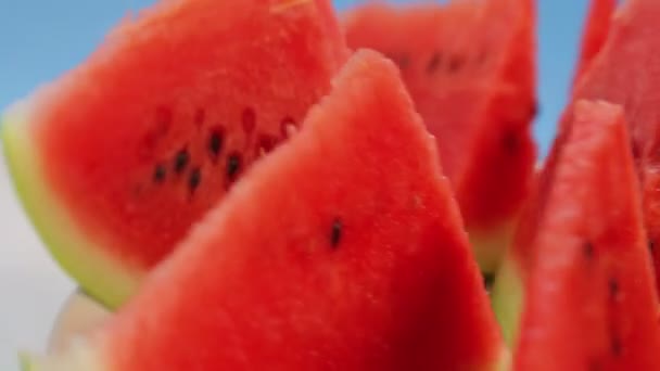 蓝色背景上成熟多汁的红色西瓜片旋转成圆形 — 图库视频影像