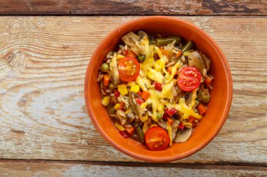 Mantarlı risotto ve ahşap arka planda kilden bir tabakta peynir..