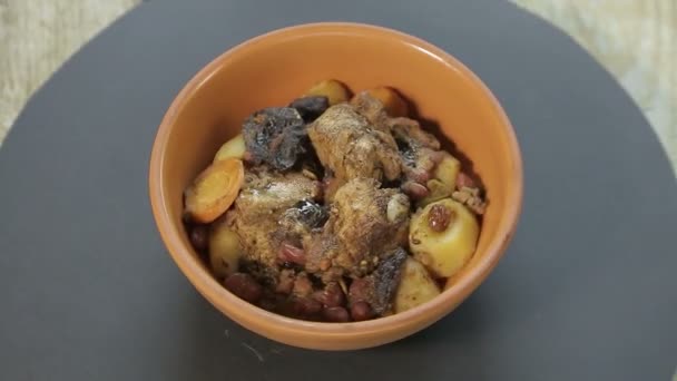 El plato judío quelnt con carne en un soporte negro gira en un círculo — Vídeo de stock