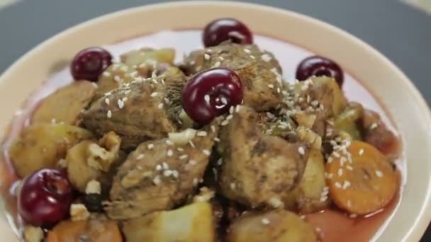 Ein jüdisches Bratengericht mit Huhn in Kirschsoße auf einem Teller dreht sich im Kreis — Stockvideo