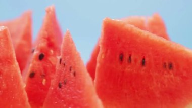 Mavi zemin üzerinde sulu kırmızı karpuz parçaları daire şeklinde döner.