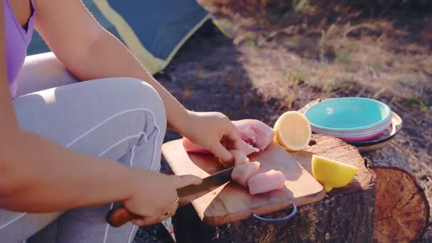 Una donna senza volto vicino a una tenda in campeggio prepara il cibo in un ambiente escursionistico — Video Stock