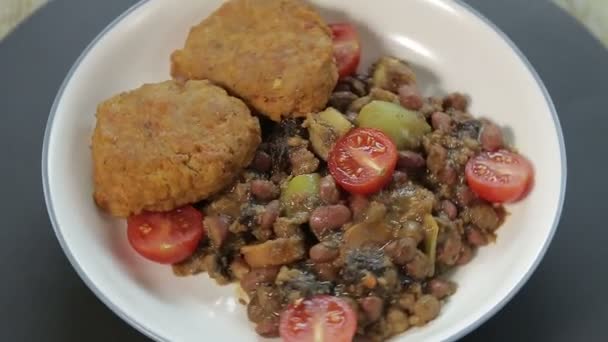 Arrosto con patate e verdure e torte di pesce su uno stand nero ruotare in cerchio — Video Stock