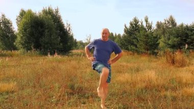 Açıklıktaki yetişkin bir adam jimnastik yapıyor..