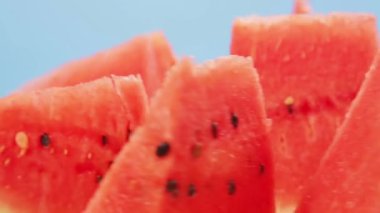 Mavi zemin üzerinde sulu kırmızı karpuz parçaları daire şeklinde döner