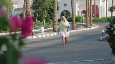 Genç bir kadın Mısır 'daki bir otelden gelirken başına pelerin takıyor.