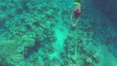 Bir kadın sualtı dünyasını keşfeder ve kamerada mercan resifini yakalar.