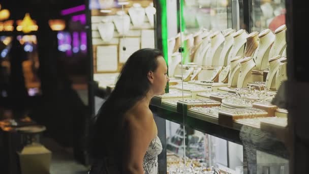 Una turista donna esamina una vetrina con gioielli — Video Stock