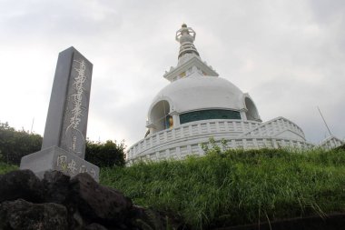 Japonya 'nın Beppu kentindeki Myohoji tapınağındaki beyaz stupa ve anıt. Haziran 2019 'da çekildi..