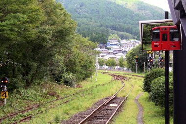 Japonya, Oita 'daki Yufuin İstasyonu' nda kırmızı tren duruyor. Haziran 2019 'da çekildi.