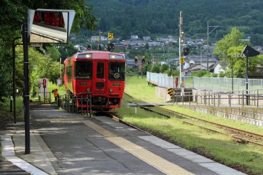 Japonya, Oita 'daki Yufuin İstasyonu' nda kırmızı tren duruyor. Haziran 2019 'da çekildi.