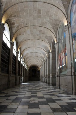 İspanya 'daki El Escorial manastırının içindeki kemer berrak mavi gökyüzünün altında, Temmuz 2024