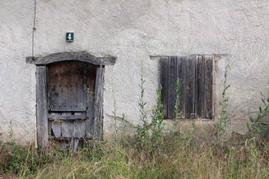 Navarre, Temmuz 2024 'te Camino de Santiago boyunca Viscarret-Guerendiain' de terk edilmiş bir kırsal evin geleneksel ahşap pencere ve kapıları..