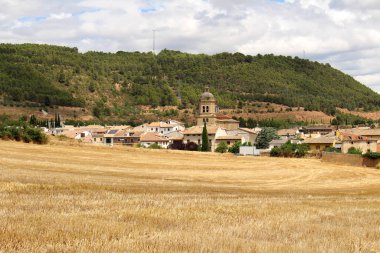 Maneru 'dan sonra Iconic Camino de Santiago manzarası, San Pedro Kilisesi ve Navarra' nın arka planında köy Temmuz 2024