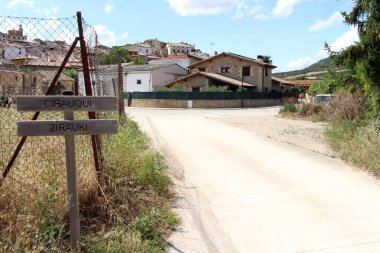 Navarra İspanya 'da Camino de Santiago rotası boyunca Cirauqui köyündeki yoğun tepe kenarındaki yerleşim yerinin işareti. Temmuz 2024
