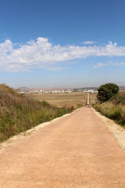 Santo Domingo de la Calzada 'ya giden toprak yolda hacılar buğday tarlalarından, kasaba binalarından ve kiliseden geçiyorlar. Temmuz 2024' ten önce görülebilir.