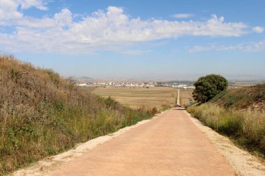 Santo Domingo de la Calzada 'ya giden toprak yolda hacılar buğday tarlalarından, kasaba binalarından ve kiliseden geçiyorlar. Temmuz 2024' ten önce görülebilir.