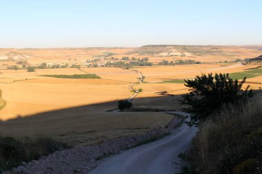 Temmuz 2024 'te Hornillos del Camino' nun uzak görüntüsü kırsal ufuk çizgisi ve Camino yolu