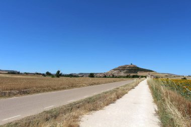 Temmuz 2024 'te Castillo de Castrojeriz ayçiçeği tarlalarının üzerinde tarihi tepe yapısı