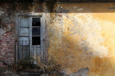 Sarı Duvardaki eski ahşap kapı Temmuz 2024 Terk edilmiş kırsal cephe ve mazgallar