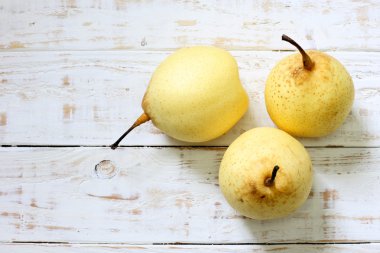 Beyaz ahşap zemin üzerinde taze oryantal armut