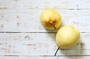 Beyaz ahşap zemin üzerinde taze oryantal armut