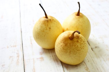 Beyaz ahşap zemin üzerinde taze oryantal armut