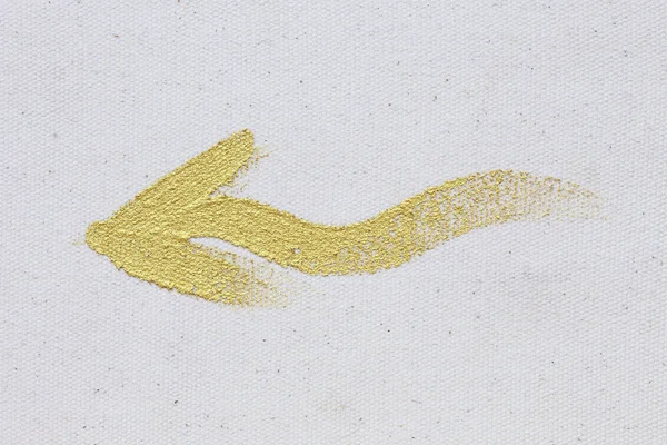 Gold arrow painting stroke on canvas background — Stock Photo, Image