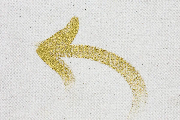 Gold arrow painting stroke on canvas background — Stock Photo, Image