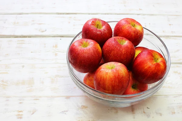 Delicious fresh apples in glass on white wood background — Stock Photo, Image