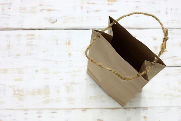 Papieren zak op een houten structuur-achtergrond — Stockfoto