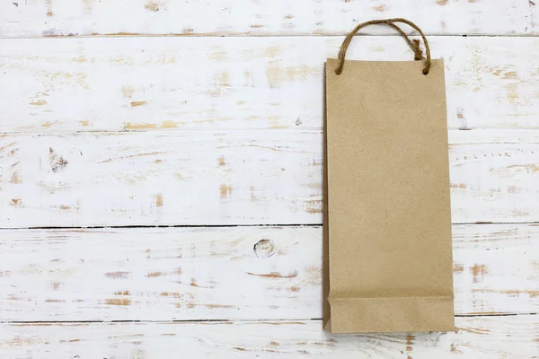 Bolsa de papel sobre un fondo de textura de madera —  Fotos de Stock