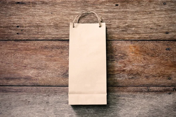 Paper shopping bag on wooden background — Stock Photo, Image