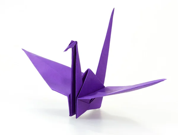 Tradiční japonské origami jeřáb z fialové papíru nad whi — Stock fotografie