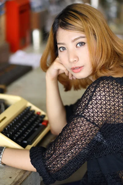 Attraktive asiatische Frau mit Schreibmaschine im Café — Stockfoto