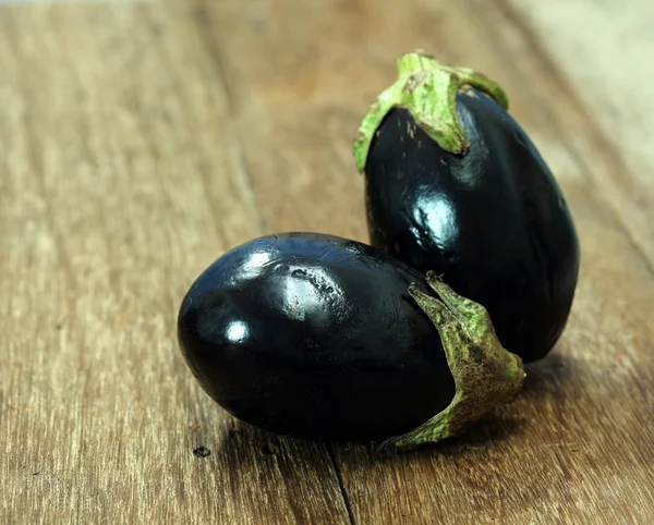 Frische Auberginen auf Holztisch — Stockfoto