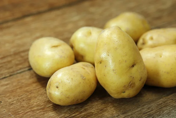 Pommes de terre crues sur une table en bois — Photo