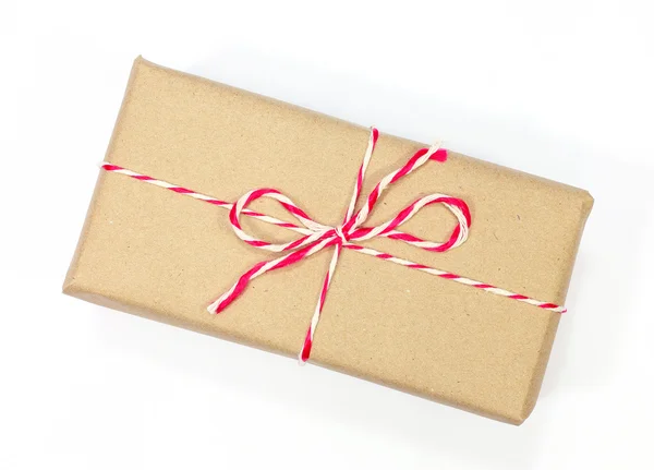 Brown paper parcel tied with red and white string on white backg — Stock Photo, Image