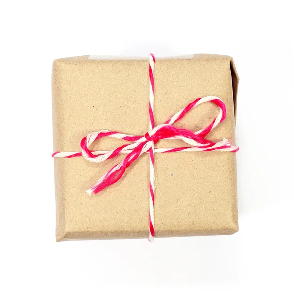 Brown paper parcel tied with red and white string on white backg — Stock Photo, Image