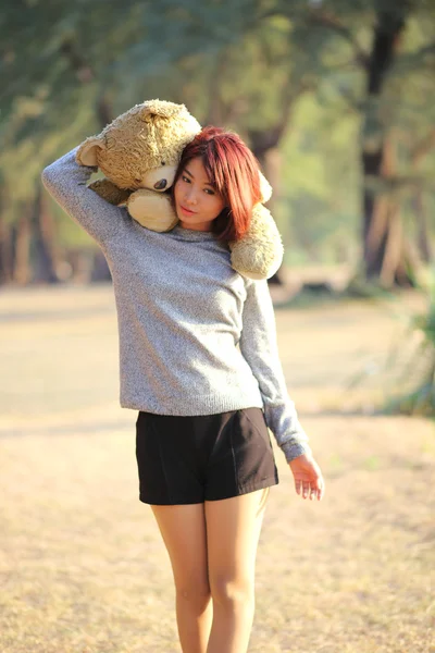Ładny asian dziewczynka gospodarstwa teddy gołe w parku — Zdjęcie stockowe