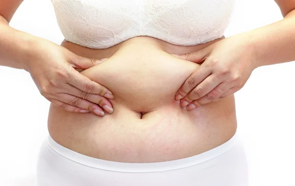 Mulher medindo sua gordura da barriga com as mãos de perto — Fotografia de Stock