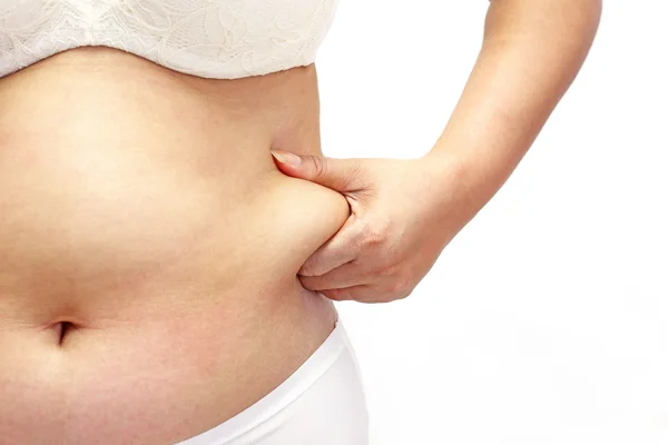 Woman measuring her belly fat with her hands close up — Stock Photo, Image