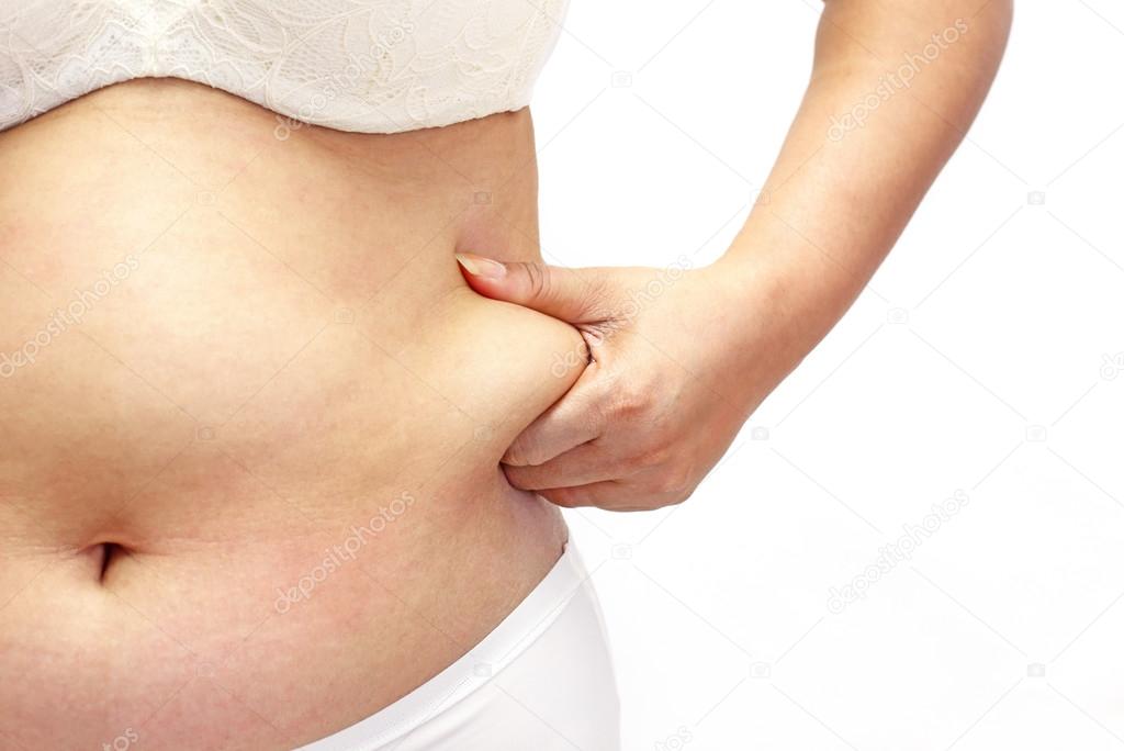 Woman measuring her belly fat with her hands close up