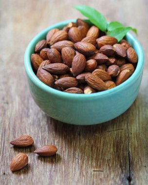 badem bir seramik kase taneli ahşap arka plan üzerinde