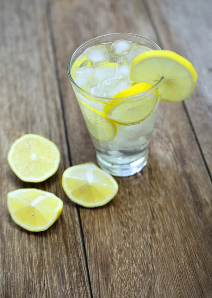 Limun segar dan soda dalam gelas di atas meja kayu — Stok Foto