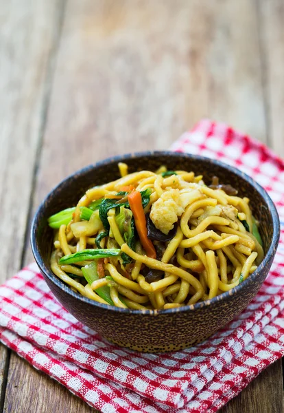 Tagliatelle fritte cinesi sul tavolo di legno — Foto Stock