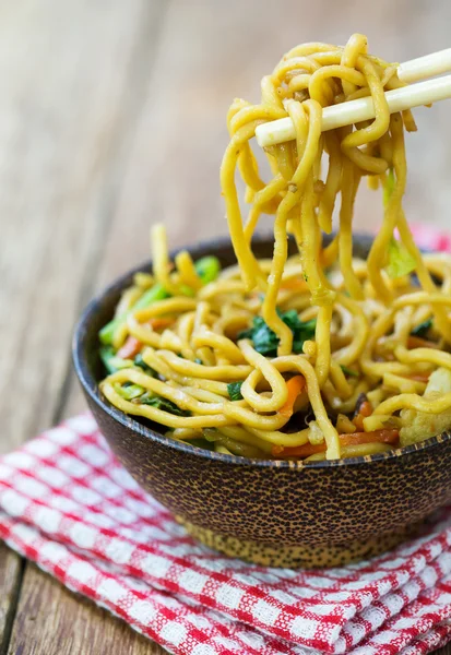 Tagliatelle fritte cinesi sul tavolo di legno — Foto Stock