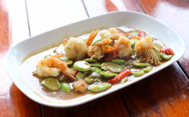 Ahşap masa üzerinde karides ile tavada kızartılmış koku fasulye